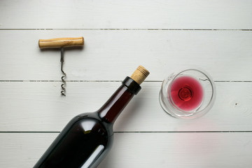 Red wine bottle on a wooden white background