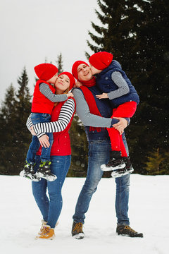 Mother, father and two sons having fun in snow winter