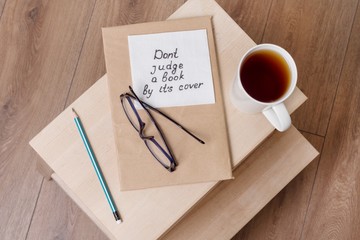Dont judge a book by its cover - a handwritten inscription on a napkin. Background book in the old...