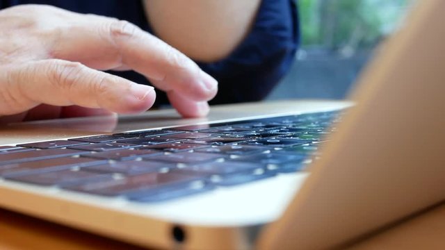 Motion of woman playing Macbook and browsing website inside subway restaurant with 4k resolution.