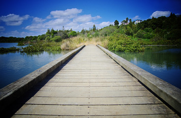 Fototapeta premium Travelling concept. Wooden pier close up, Lake, nature and blue sky in the background.
