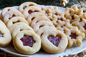 Traditional Linzer Christmas cookies with strawberry jam arranged on a plate