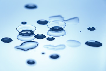 contact lenses with water drops on reflective surface.