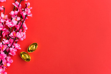 Chinese New Year Background Ornaments, Plum Flowers and Gold Ingots with Chinese Word Happiness and Prosperity. Red background.