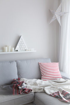 A comfortable nom with an advent tree , a pillow and a cozy blanket. 