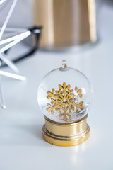 Glass snow globe with a golden snowflake inside. 