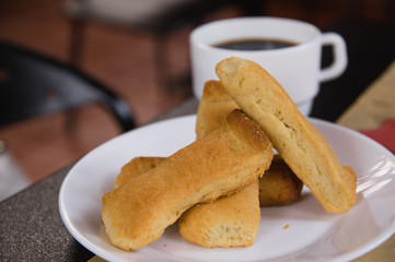 Close up of a plate of bisquit typical andean food region, with a blurred cup of coffe behind, sponge biscuits of Cayambe, Ecuador