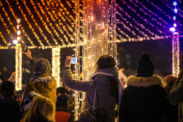 Christmas market and concert in city centre. People enjoying event, taking pictures and videos....