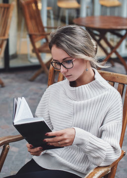 Portrait of woman reading a book outdoors