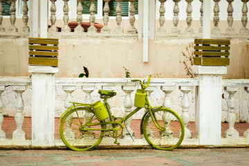 Fototapeta na wymiar Green retro bicycle on the background of an old balustrade