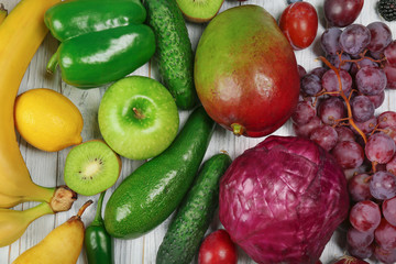 Creative composition made of fruits and vegetables in rainbow colors on wooden background, flat lay