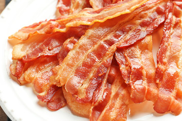 Cooked bacon rashers on plate, closeup