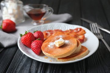 Tasty breakfast with pancakes, bacon and strawberry on plate