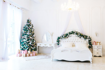 Christmas living room with a Christmas, gifts tree and bed. Beautiful New Year decorated classic home interior. Winter background