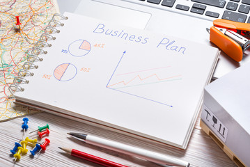 Office desk with business plan, top view