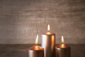 Silver burning candles on light background
