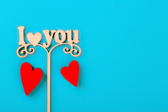 Valentine day concept. Inscription I love you with red decorative hearts on blue background. Free space for your text.