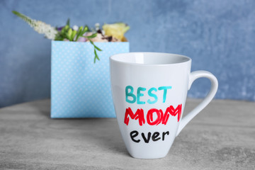 Cup with text BEST MOM EVER for Mother's day on table