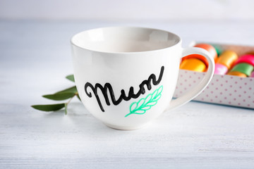Cup with word MUM for Mother's day on table