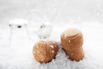 Champagne corks with caps on white snow