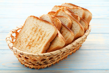 Toast bread in basket on blue wooden table