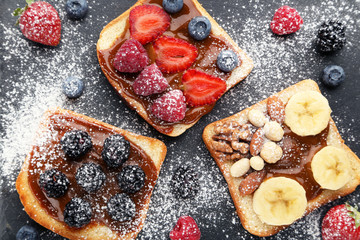 Toasts bread with berries on grey wooden table