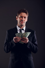 Picture of man in suit counting dollars