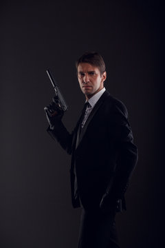 Photo of mafia man in leather gloves with gun isolated