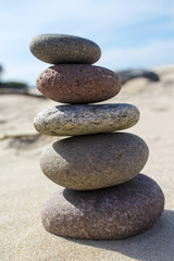 Fototapeta na wymiar Pyramid of pebbles on sand