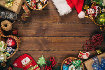 Christmas background with gifts, toys, tree branches, New Year decor, candies, and gingerbread cookies on old wooden background. Frame with free space. Merry Christmas greeting card