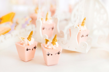 Fototapeta na wymiar lots of sweet pink mini cakes in the form of a unicorn