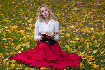 Pretty woman reading book sitting on the grass