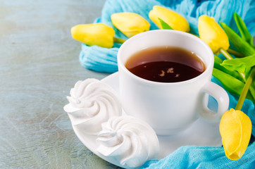 Delicious meringue cookies and cup of hot tea.