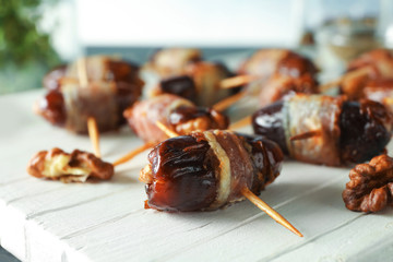 Wooden board with bacon wrapped dates, closeup