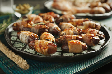 Plate with bacon wrapped dates on wooden tray