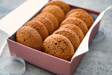 Box with delicious oatmeal cookies on table, closeup