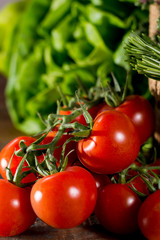 Fresh green lettuce salad, italian kitchen herbs and tasty cherry tomatoes on vine