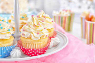 Stand with delicious cupcakes on table, closeup