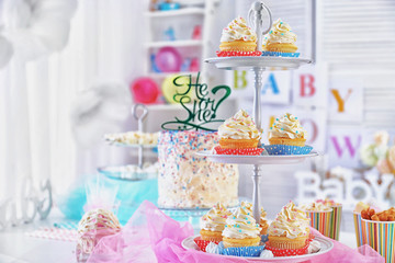 Stand with delicious cupcakes on table