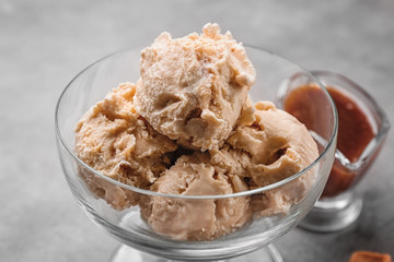 Delicious ice cream in glass bowl on grey background