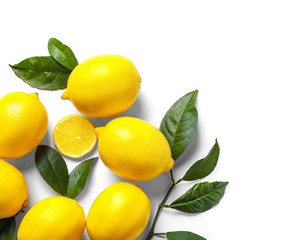 Composition with lemons and green leaves on white background