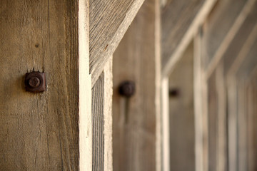 Row of identical Wooden Beams with Rusty Screws Construction Supporting a Roof