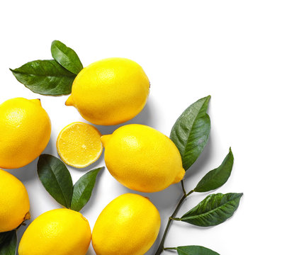 Composition with lemons and green leaves on white background