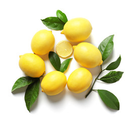 Composition with lemons and green leaves on white background