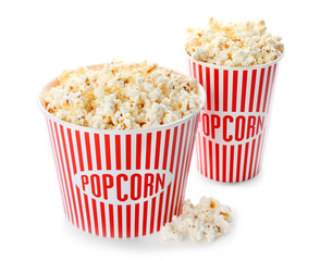Cups with popcorn on white background
