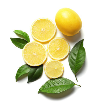 Composition with lemon and green leaves on white background