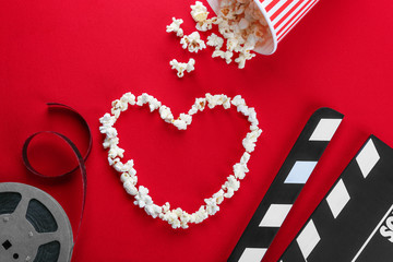 Composition with popcorn and cinema film on color background