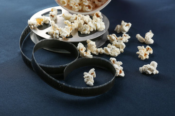 Composition with popcorn and cinema film on dark background