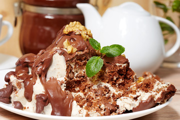 Delicious chocolate biscuit cake with milk cream and walnuts. Sweet dessert.