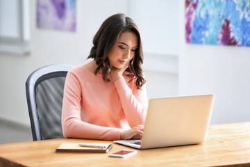 Young woman using laptop in office